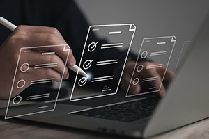Person writing at their laptop with checklist concept