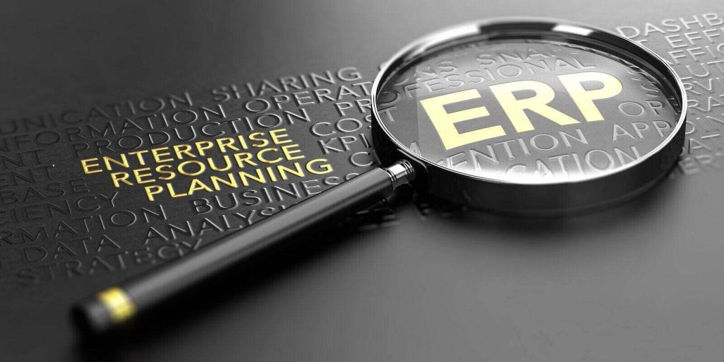 magnifying glass over black background and focus on the golden acronym erp